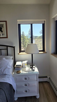 photo of nightstand with window behind, views of mountains and trees