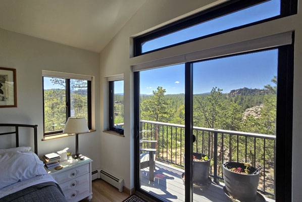 photo of bedroom with large sliding glass doors with transom and balcony outside