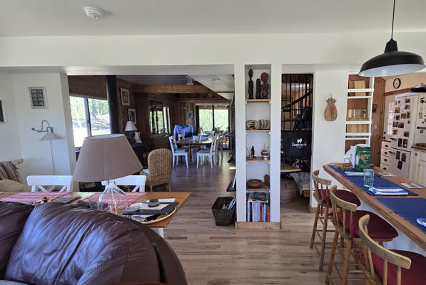 photo of living room with built-in bookshelf, warm wood floors and a peninsula island with seating