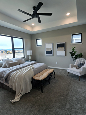 photo of bedroom with large windows above the bed, small high windows on the side, a black angular ceiling fan, and carpet
