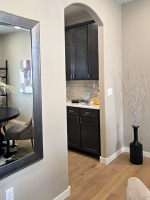 photo of a butler's pantry with dark wood cabinets and white tile backsplash