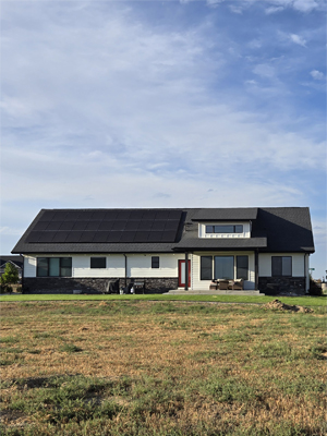 photo of back of ranch house with covered patio and solar panels